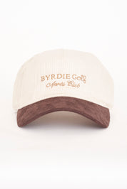 A beige and brown corduroy hat with 'BYRDIE GOLF Après Club' embroidered on the front.