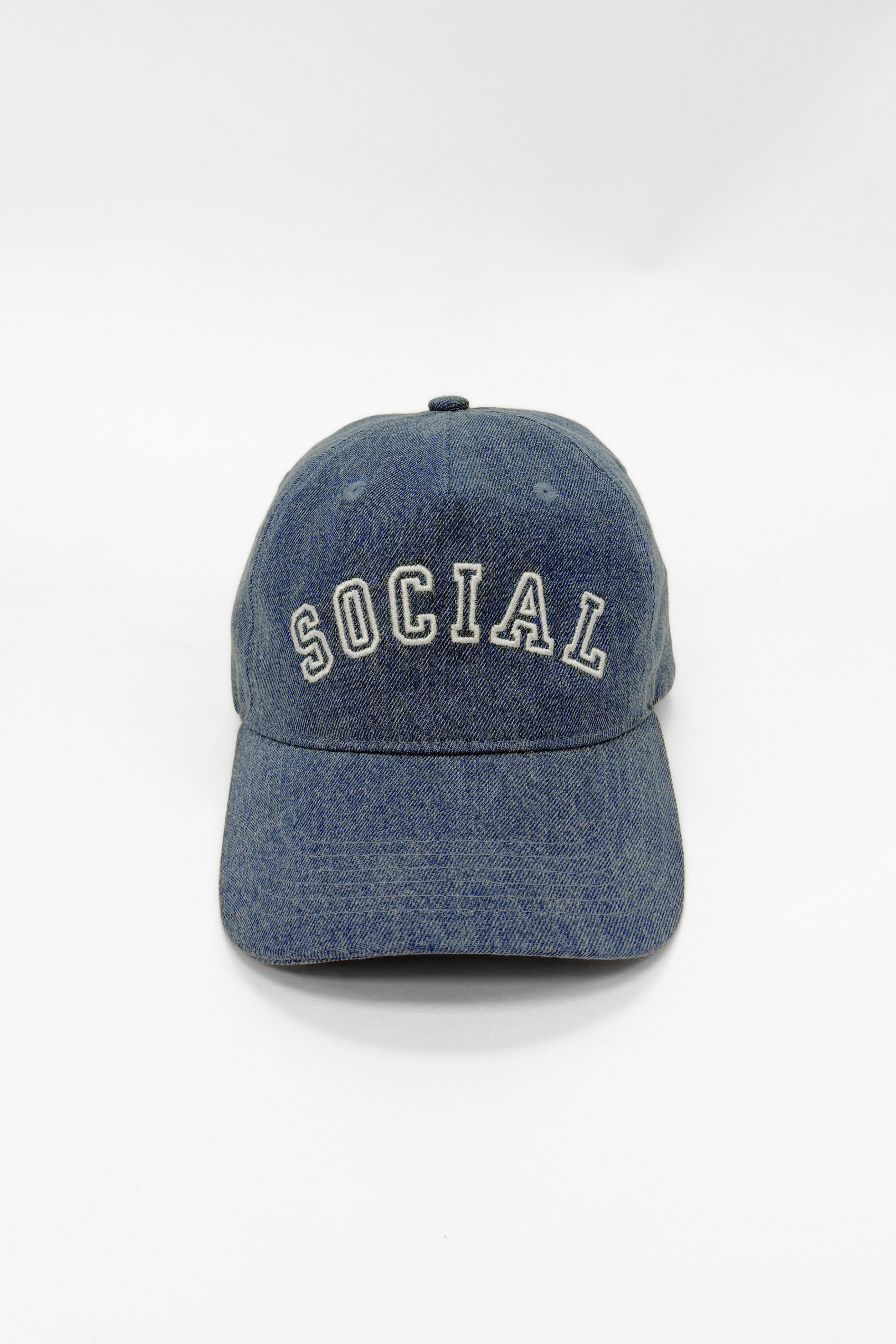 Blue denim cap with 'SOCIAL' embroidery on a white background