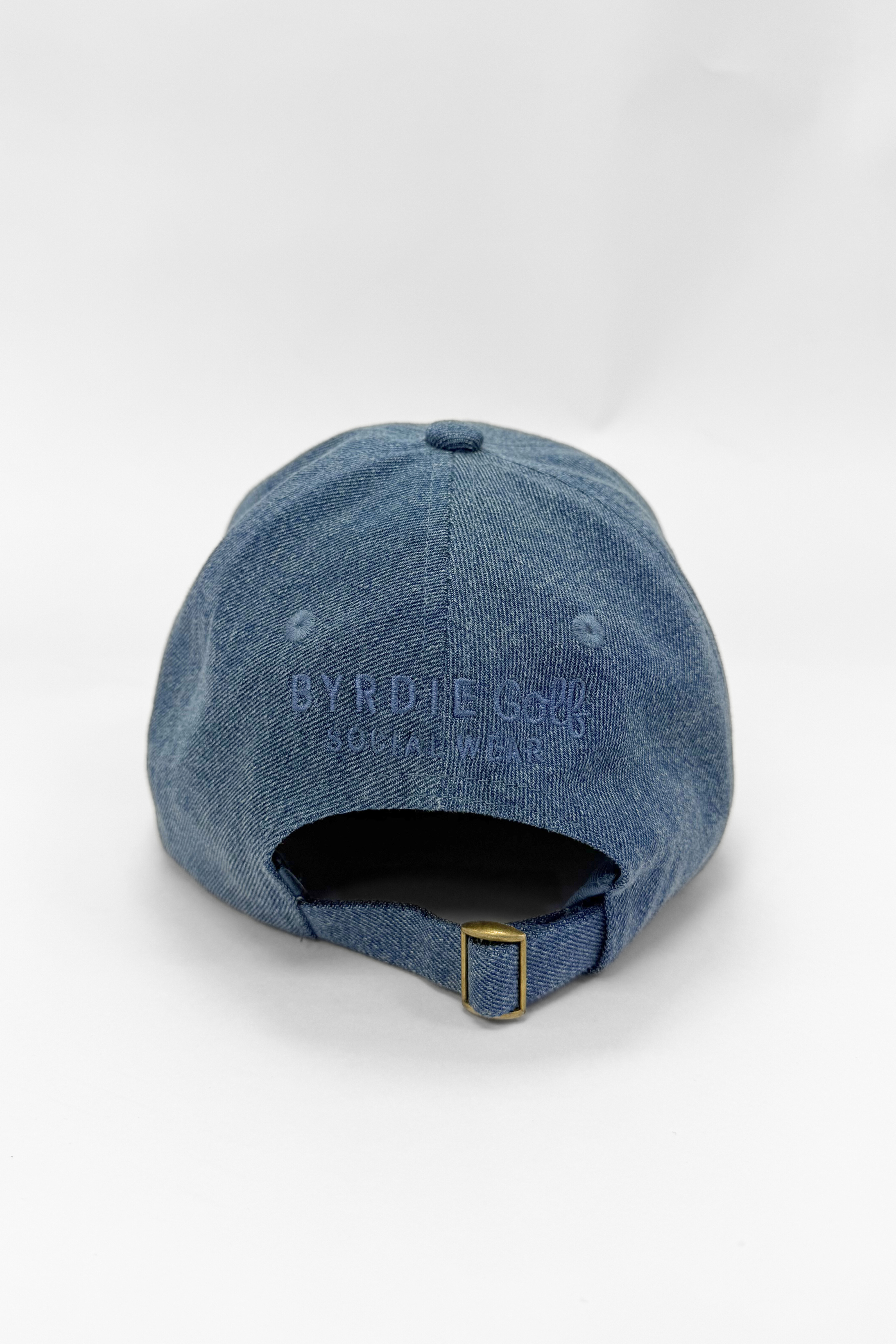 Blue denim cap with 'Byrdie' branding on a white background
