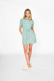 Woman wearing a green patterned dress on a white background